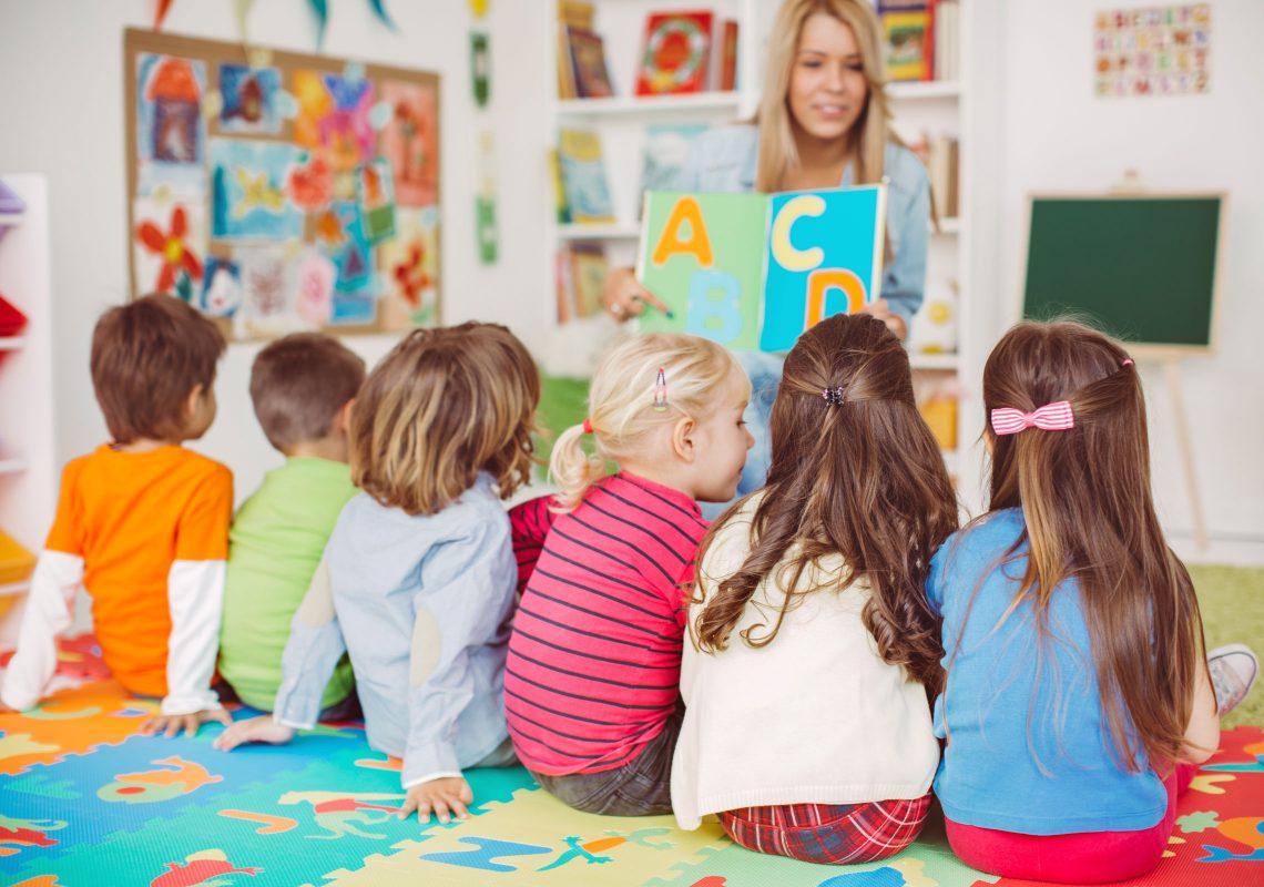 a librarian reading an abc book to six children