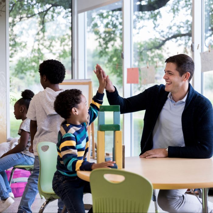 little boy gives a high five to librarian