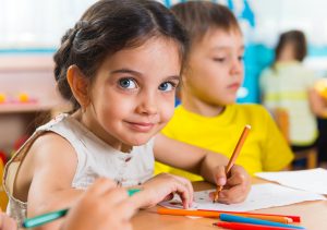 little girl coloring with markers